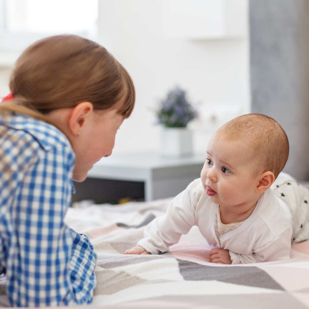 A baby and an older child facing each other, highlighting that eye contact comfort levels vary in autism