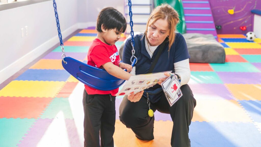 A therapist and a child interacting during an ABA session to build social engagement skills
