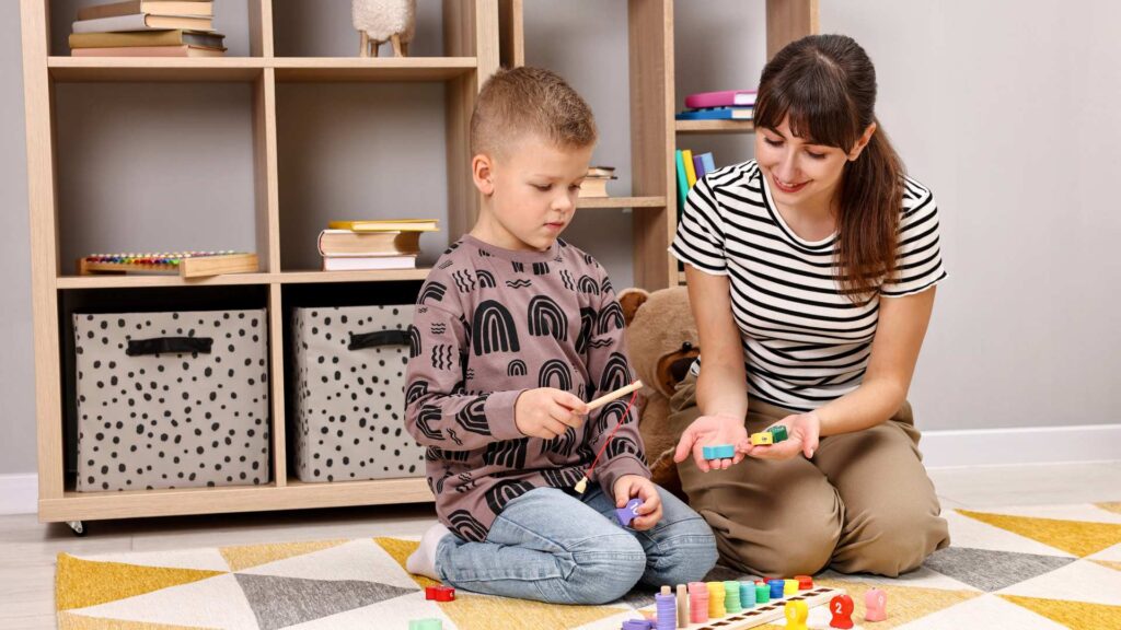 Adult supporting a child during a simple toy‑based task that could be used in ADHD and autism evaluations