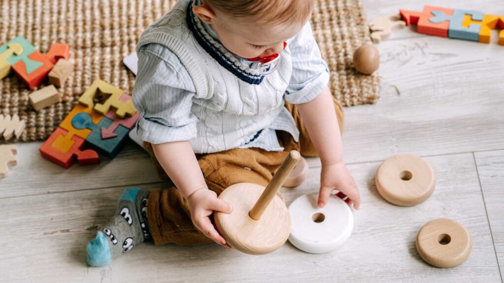 Toddler playing with stacking toy during an ABA therapy activity that supports early learning