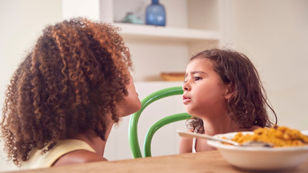 Parent supporting a picky eating child during a challenging mealtime