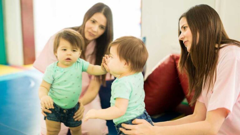 Specialists observing a toddler during an early autism diagnosis screening