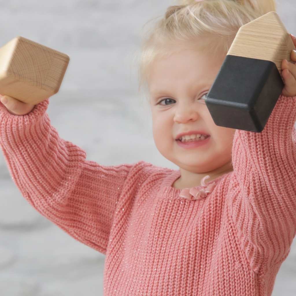 Toddler exploring wooden blocks during an early intervention play activity in ABA therapy for toddlers