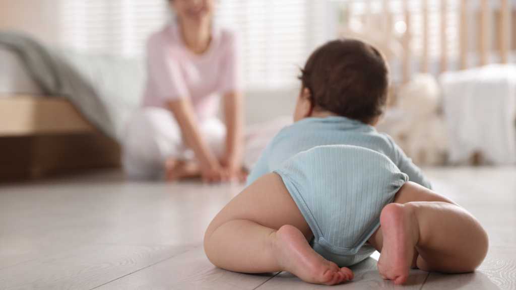 Infant crawling toward caregiver during an activity that supports early intervention for autism