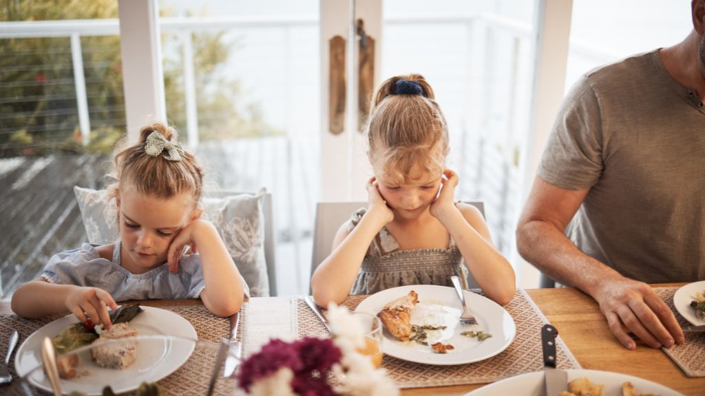Children showing reluctance to eat during a family meal