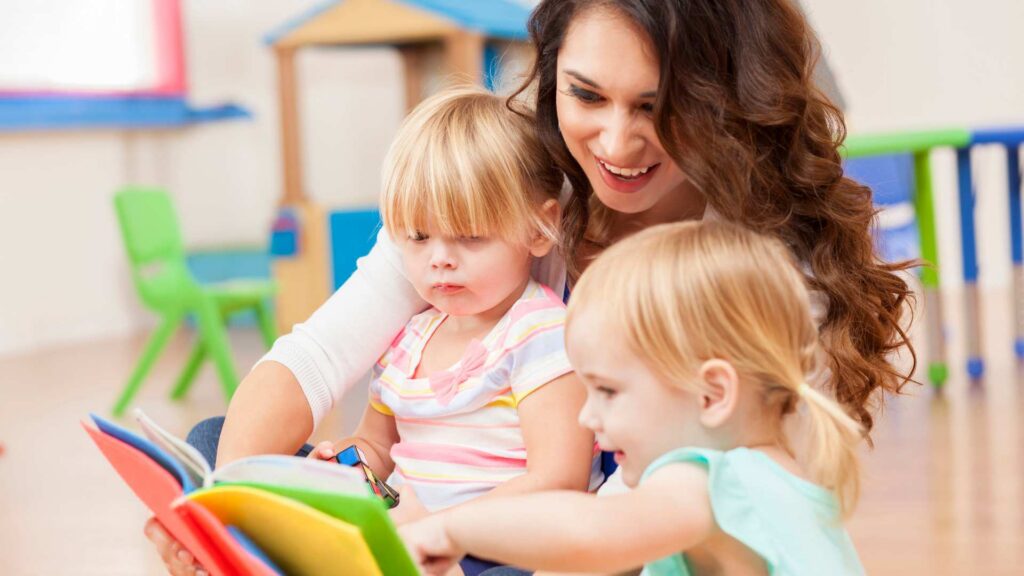 Therapist reading with toddlers during a play-based ABA therapy session